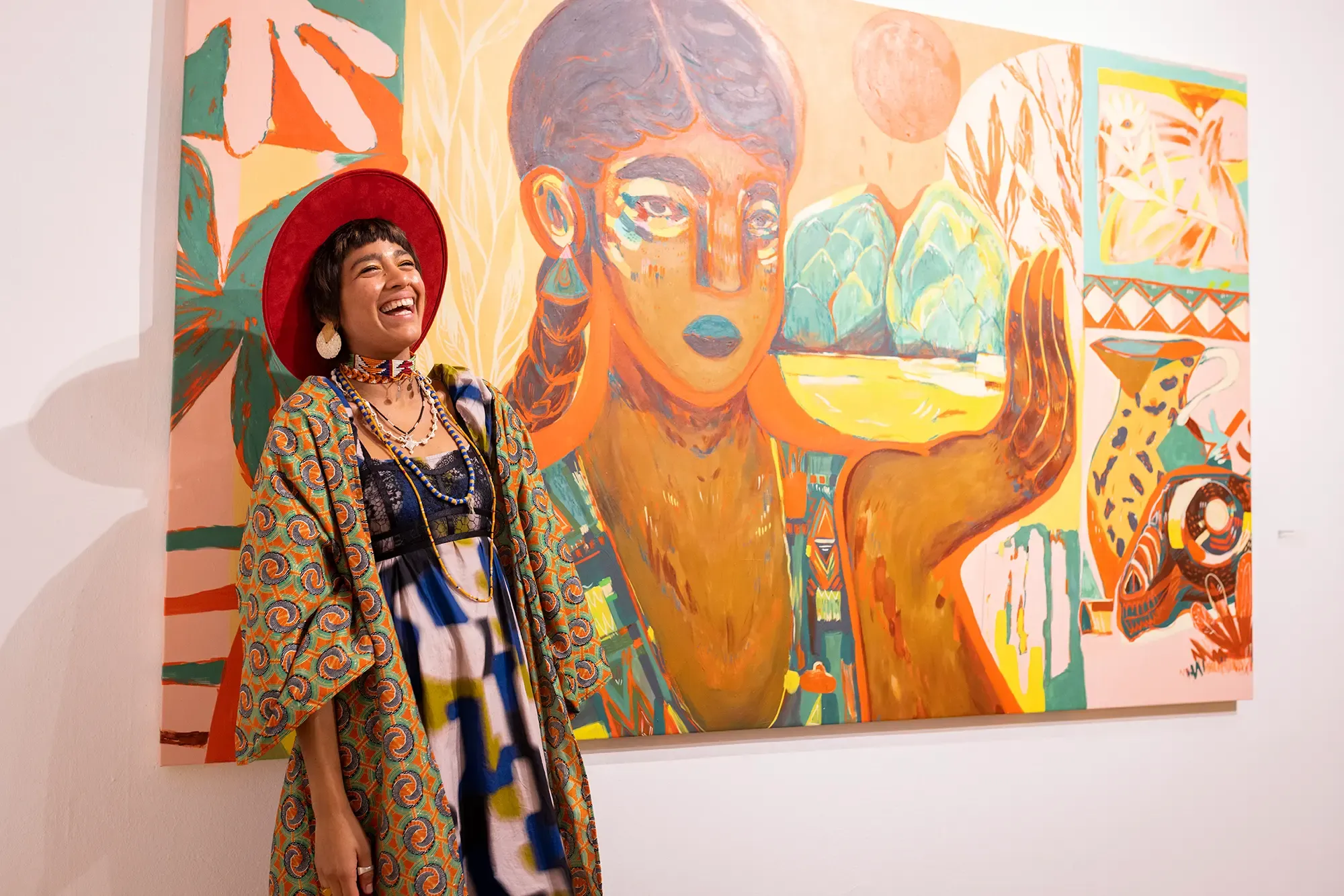 jumu monster, promising contemporary artist, in front of a Hughe painting, colorful, ancient latin America, storytelling