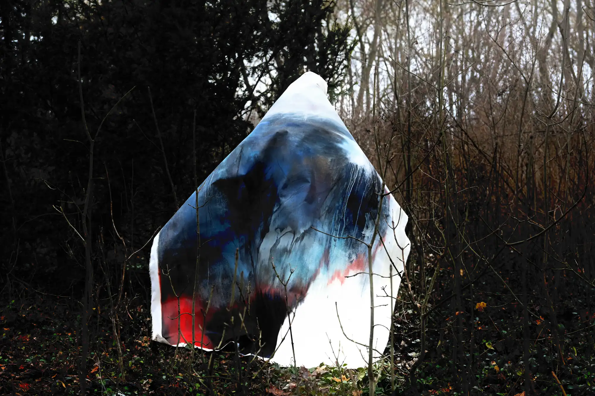 Igigo Wu in theatrical costume during 'Walking Landscape' at Zentralfriedhof Vienna, partially veiled, gazing through fabric in performative gesture