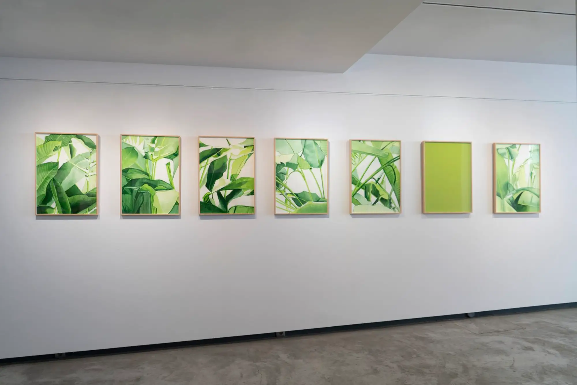 Installation shot showing multiple works on canvas arranged in vertical rhythm