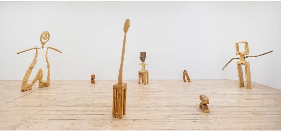 Wide view of Hunter Potter’s “The Pasture” at SHRINE Gallery, New York City, showing an array of carved wooden sculptures arranged throughout the gallery’s bright, open space.