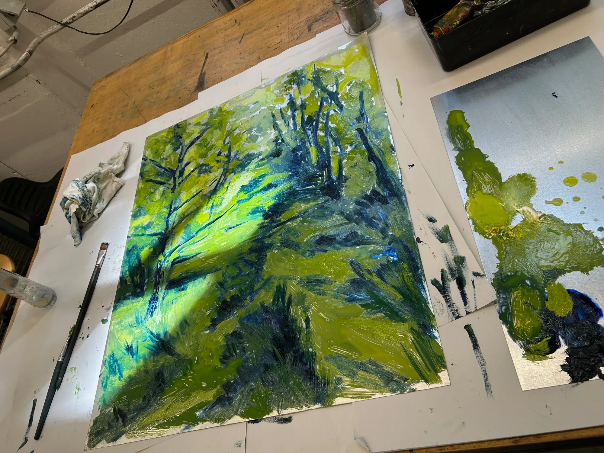 Candy Bassas, painting in progress, Berlin studio view, canvas on table with brushes and oil palette.