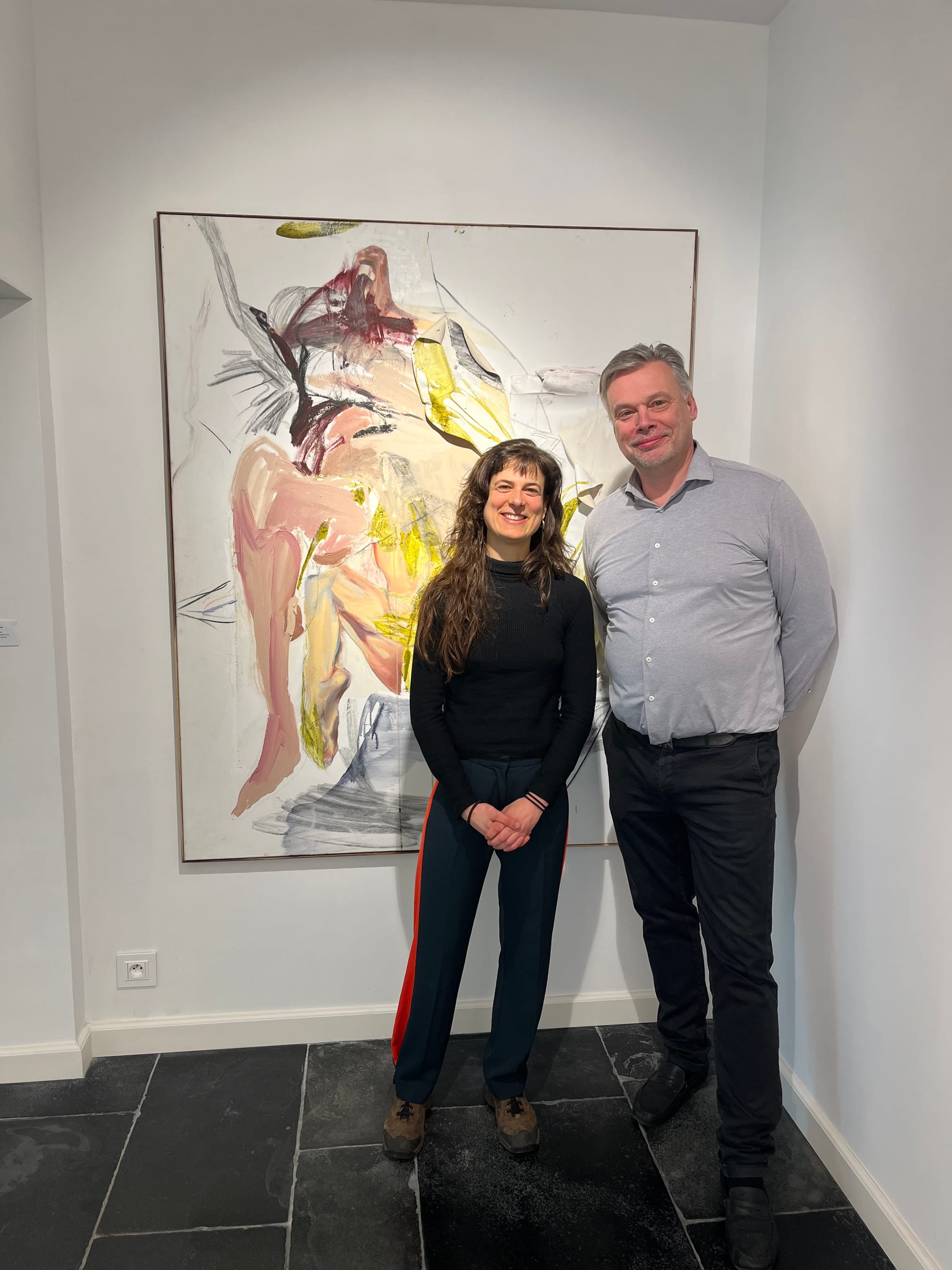 Ruth Devriendt and gallerist Kristoff Tillieu standing in front of a large abstract painting during their interview with Di Franco at Black Swan Gallery. Photo by Di Franco 2025.