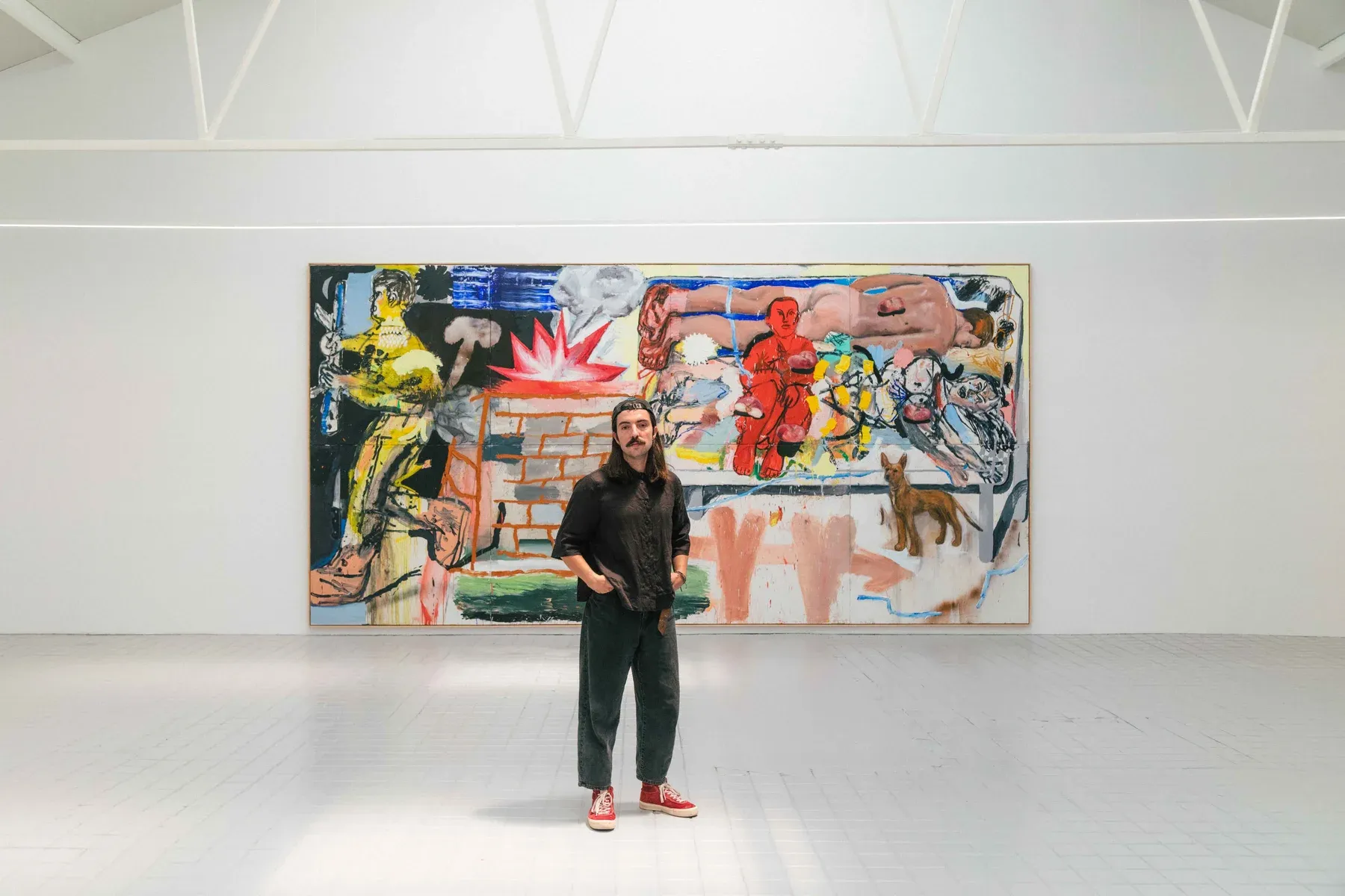 Manuel García Fernández stands in front of his large-scale painting during Dog Bed Games, his 2025 solo show at Marc Bibiloni Gallery, Madrid. Photo by Santino Lamorte.
