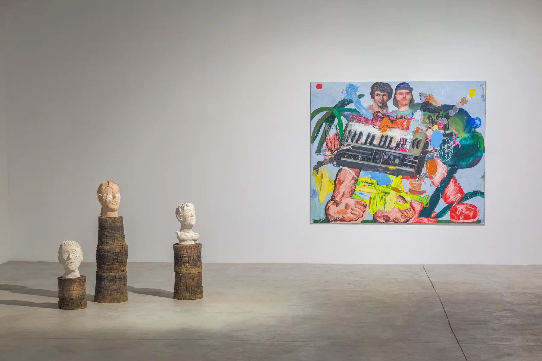 Installation view of Pintura para construir en tu cabeza by Manuel García Fernández, 2024. A colorful figurative painting and ceramic busts on wooden pedestals at La Bibi Gallery.