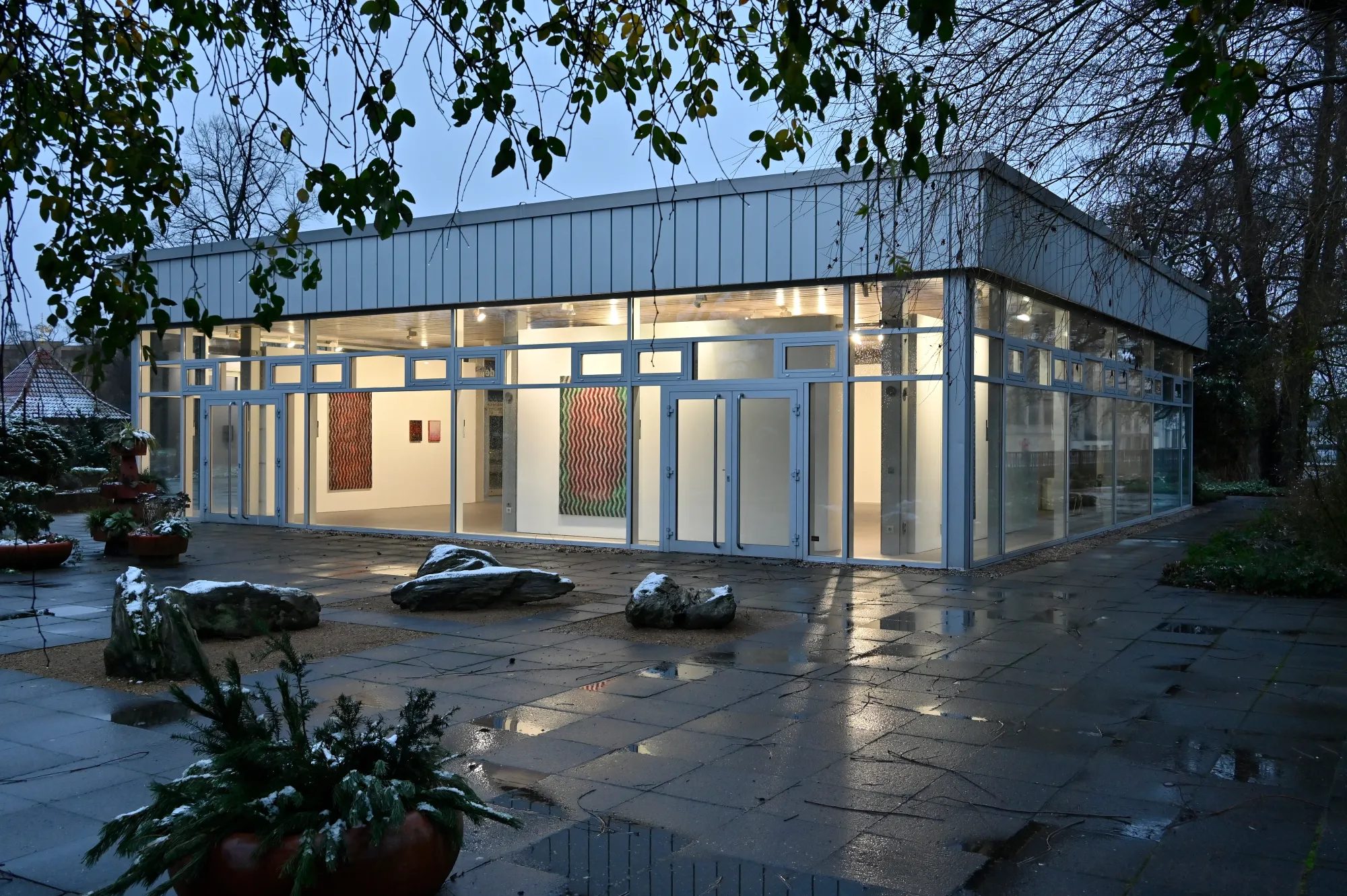 Matthias Esch, Deranged Chanting exhibition view II, 2024, exterior evening view of Kunstverein gallery with illuminated abstract paintings visible inside, photo by Michael LĂŒder.