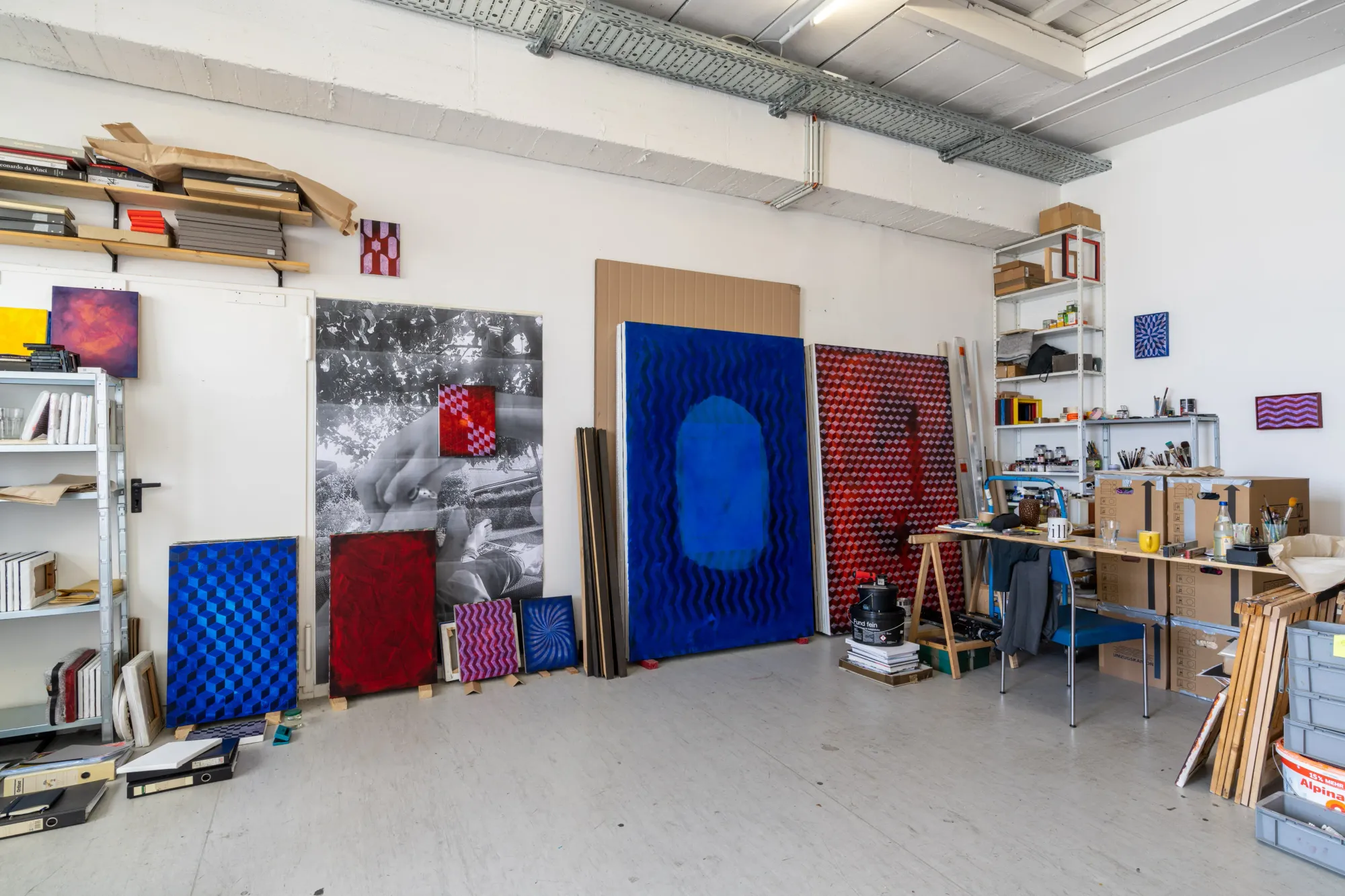 Matthias Esch: Studio View. Artists studio, very clean and tidy, with red and blue abstract paintings by the artist