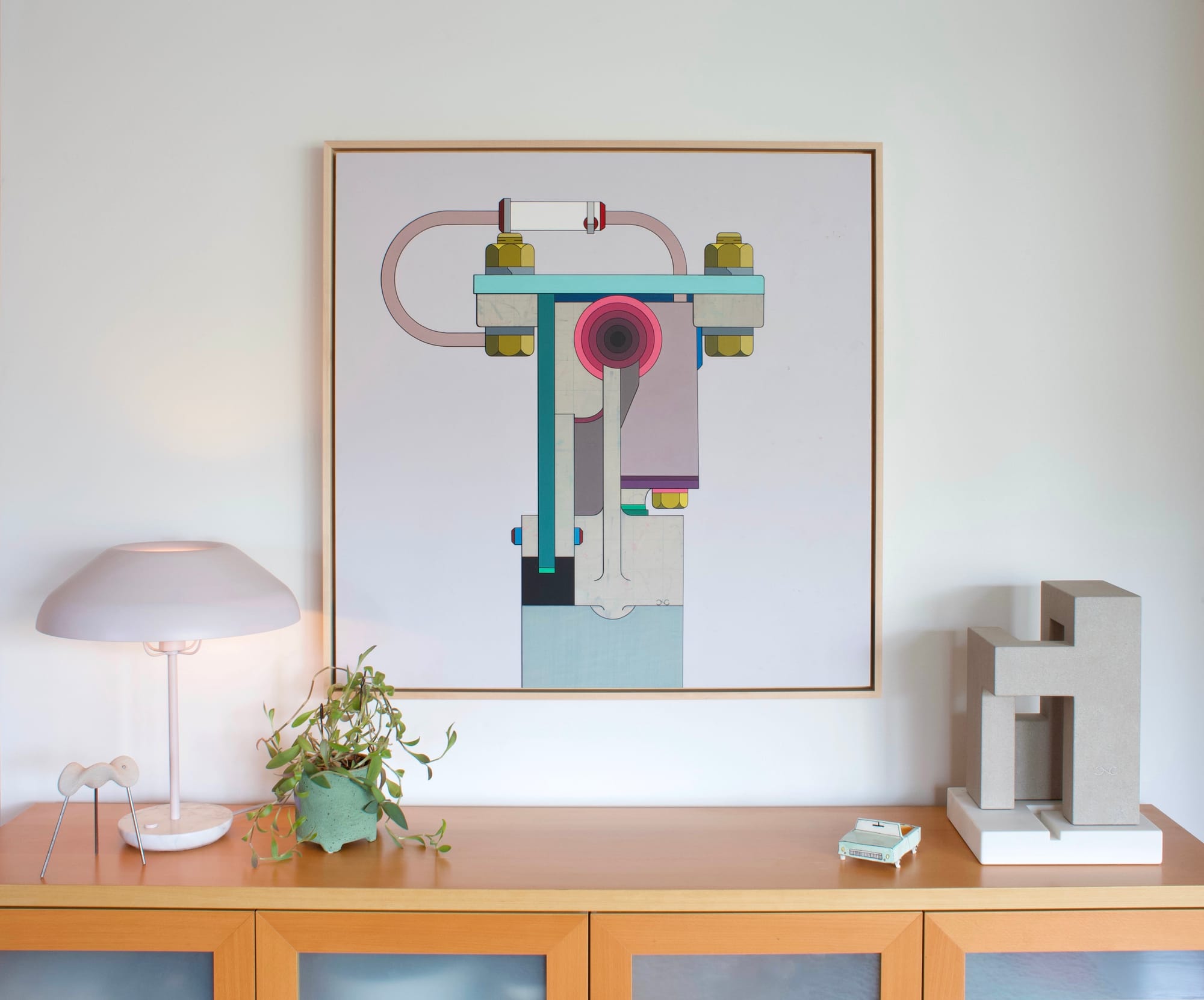 Painting ‘Kickout’ and stone sculpture ‘Edifice No.16’ by Chris Cassimatis displayed in a Portland interior in 2024, shown on a wooden sideboard with lamp and objects. Courtesy of the Artist.