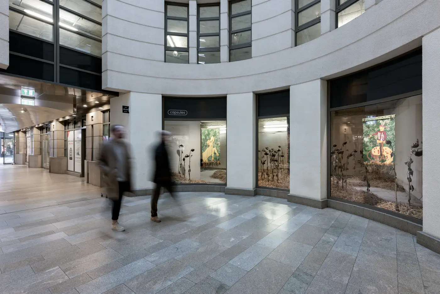 Installation view of HUNT(ED) by Olivia Rode Hvass at Luxembourg Art Week. The work, curated by Çağla Erdemir, features large woven tapestries surrounded by dried sunflowers and straw. Photographed by Patty Neu.