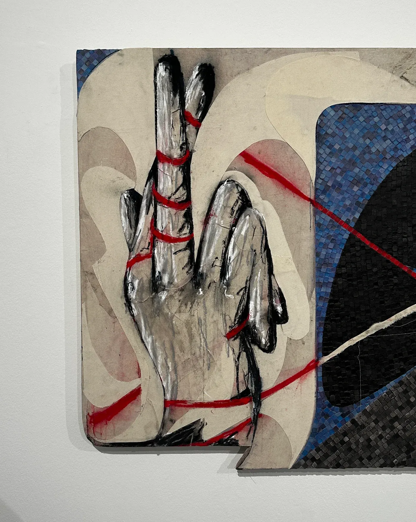 Close-up of Egor Lovki’s mosaic work from the exhibition “I Smiled but Misunderstood” at Bildraum 01, Vienna, showing a painted hand form wrapped with red lines against a background of blue and black tesserae.