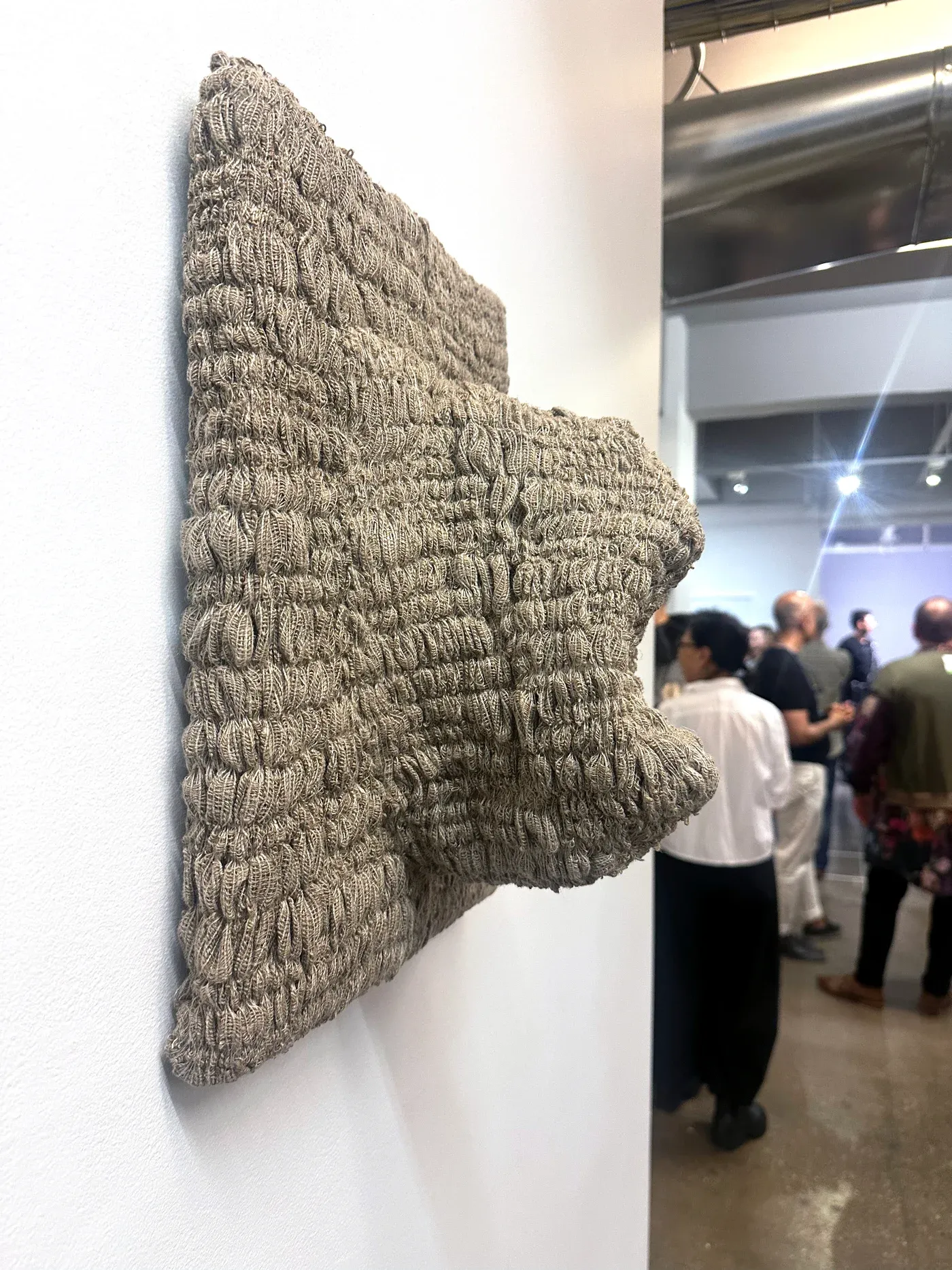 Yali Romagoza, Skin Panel #1 (2024), linen and thread on wood panel, close-up view showing textured woven surface extending from the wall during Result by Chance exhibition at The Elizabeth Foundation for the Arts, NY.