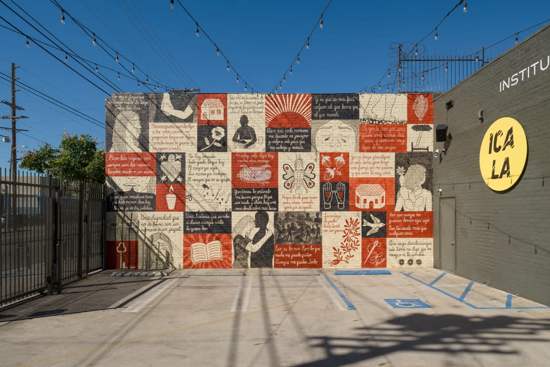 Outdoor mural at ICA LA composed of red, black, and cream squares with hand-painted figures and text, installed across a brick wall.
