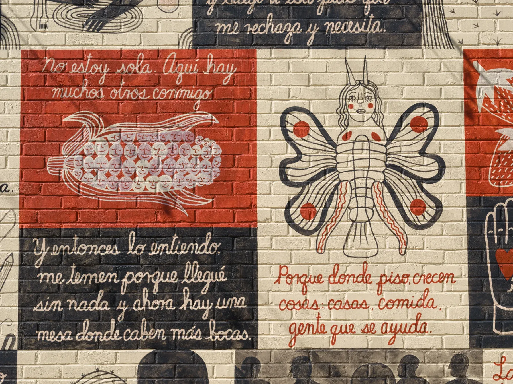 Close-up of the ICA LA mural showing a butterfly-like female figure and hand-painted Spanish text blocks on brick.