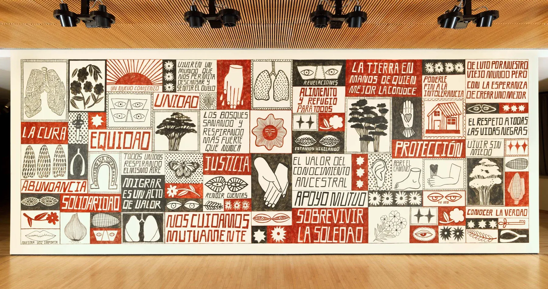 Wide view of a red-and-black tiled mural at SFMOMA featuring symbols, text blocks, and figurative motifs across an entire gallery wall.