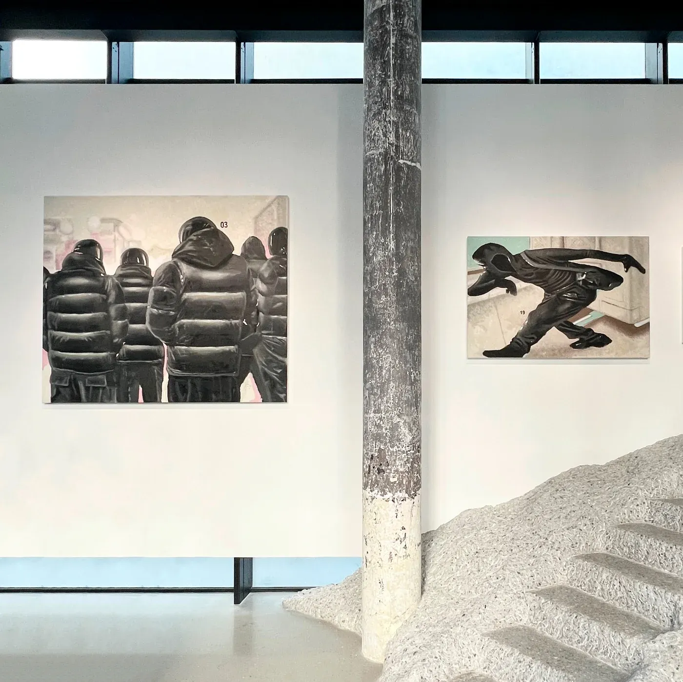 Yutaro Inagaki, Two large paintings of hooded puffer jacket figures installed in a gallery beside a sculptural ramp.