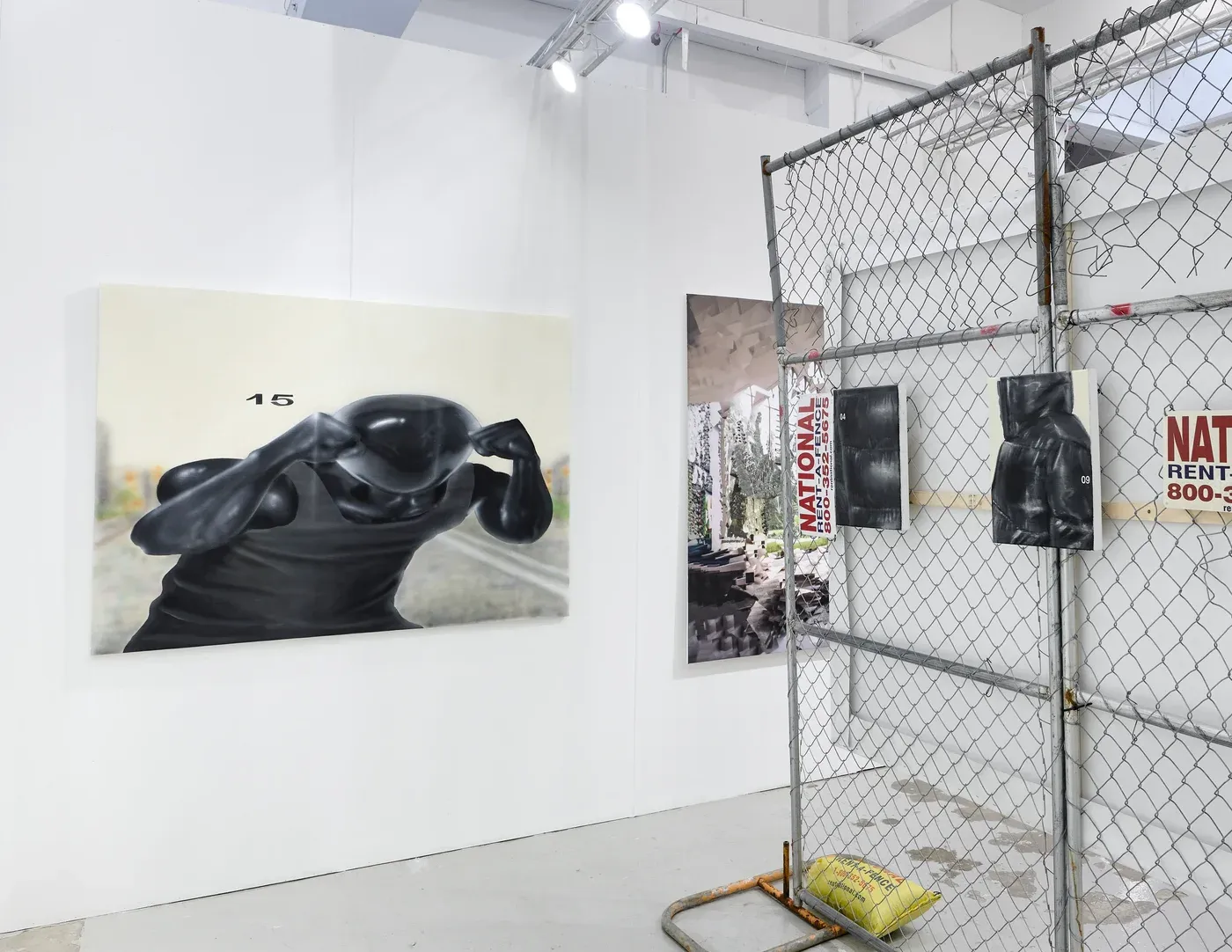 Yutaro Inagaki, Booth installation with a large painting of a glossy black puffer figure displayed beside chain link fencing and a mounted black sculptural piece.