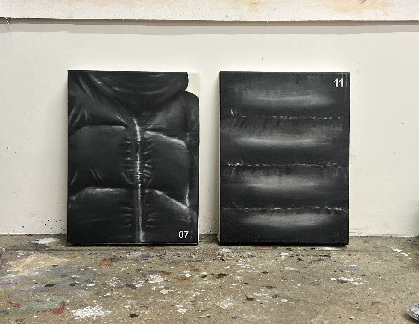 Yutaro Inagaki, Two monochrome canvases showing close up surfaces of black puffer jackets with soft light and texture.