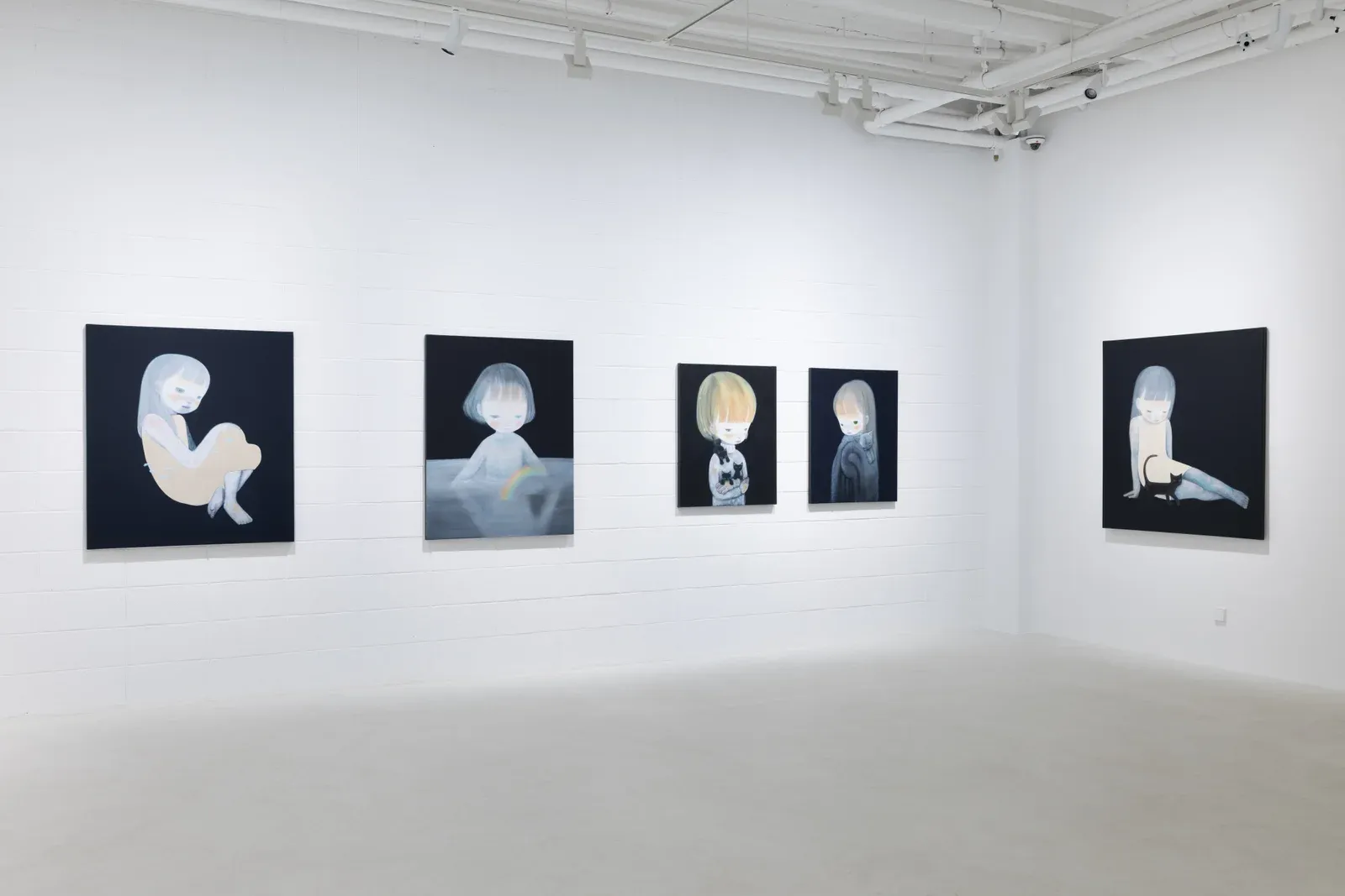 Wide installation view of multiple paintings by Ruo-Hsin Wu displayed across white gallery walls at Eligere Gallery, featuring pale figurative figures set against dark backgrounds.