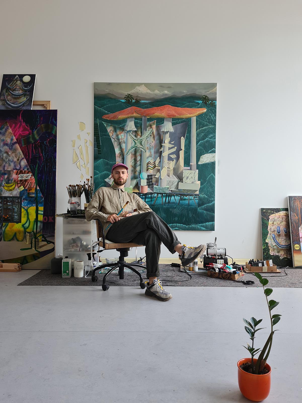 Maxim Brandt - artist in his studio in front of his paintings