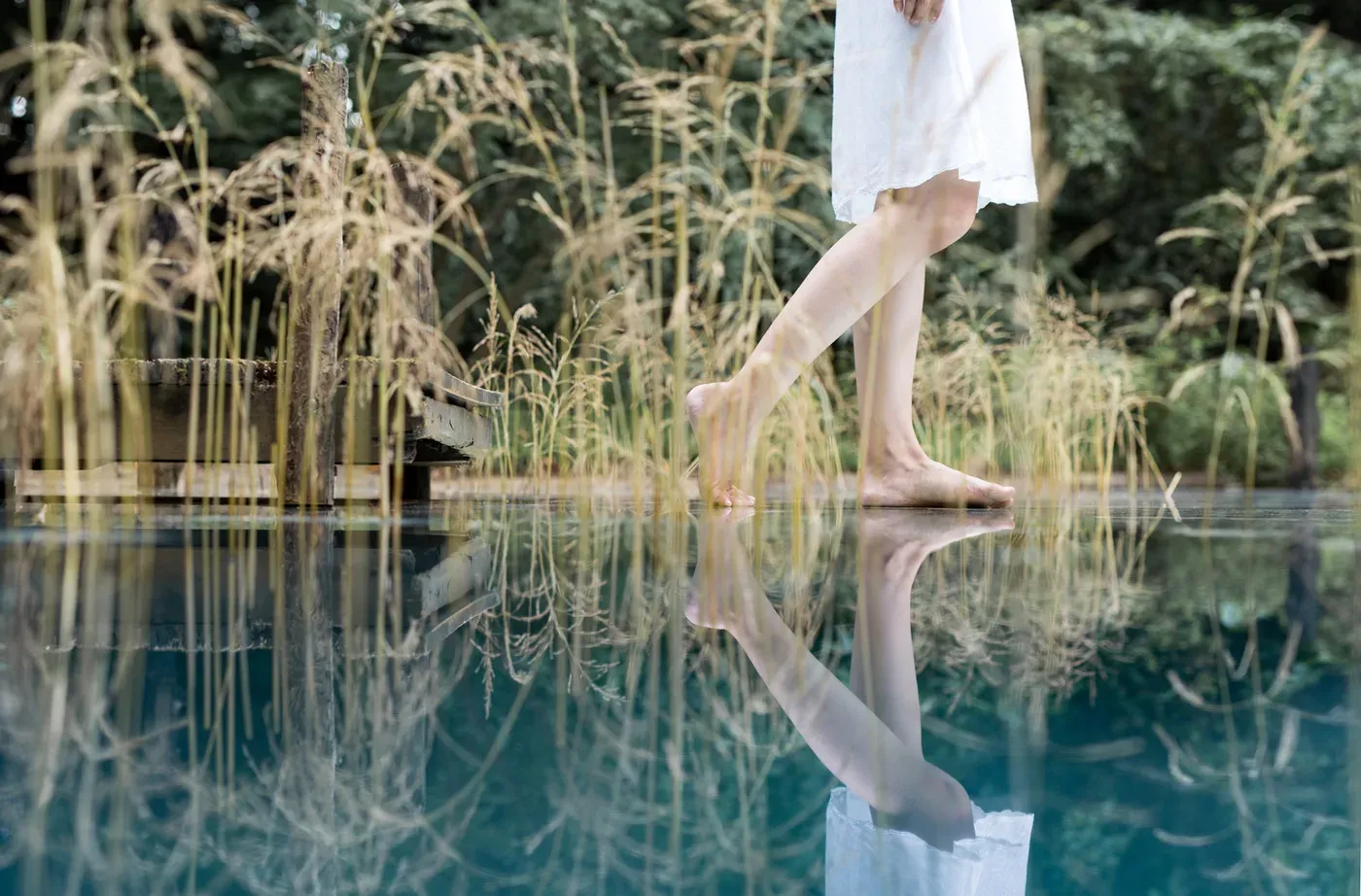 Bare feet walking across a reflective water surface in 目 [mé]’s installation Elemental Detection  at the Former Saitama Prefectural Folklore Museum, Saitama Triennale