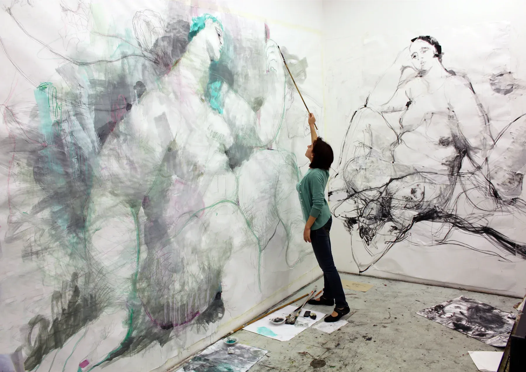 Maria Naidyonova, female artist, painting on a large canvas in her studio