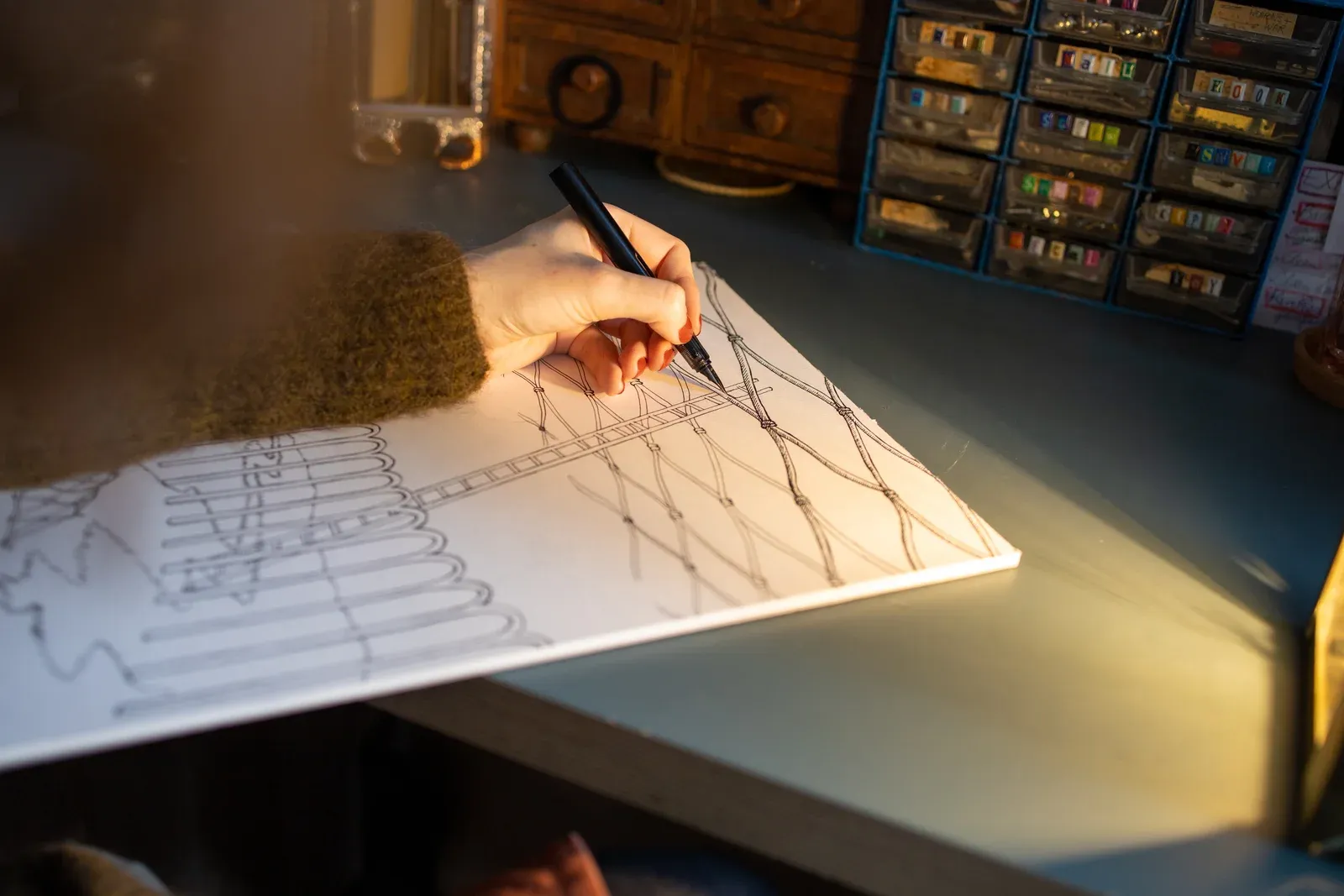 Martha Kicsiny working in her studio in Ghent, surrounded by drawings and light-based lithophane objects.