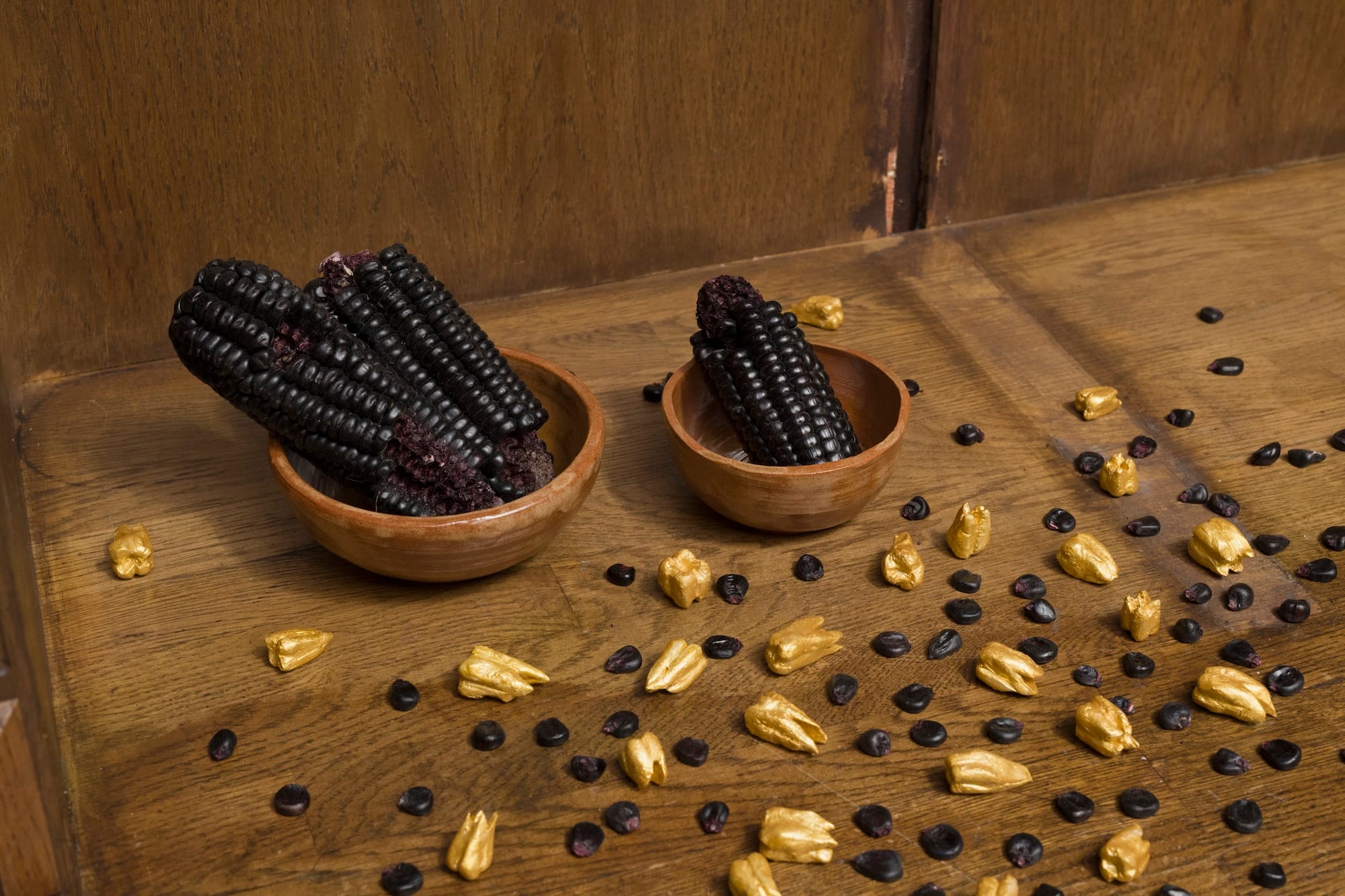Installation detail of ofrenda IV / offering IV (2025) by Inés Cardó, featuring purple maize cobs, ceramic bowls, and gold-painted clay teeth in the exhibition Bitter Spring at MARA Projects, London