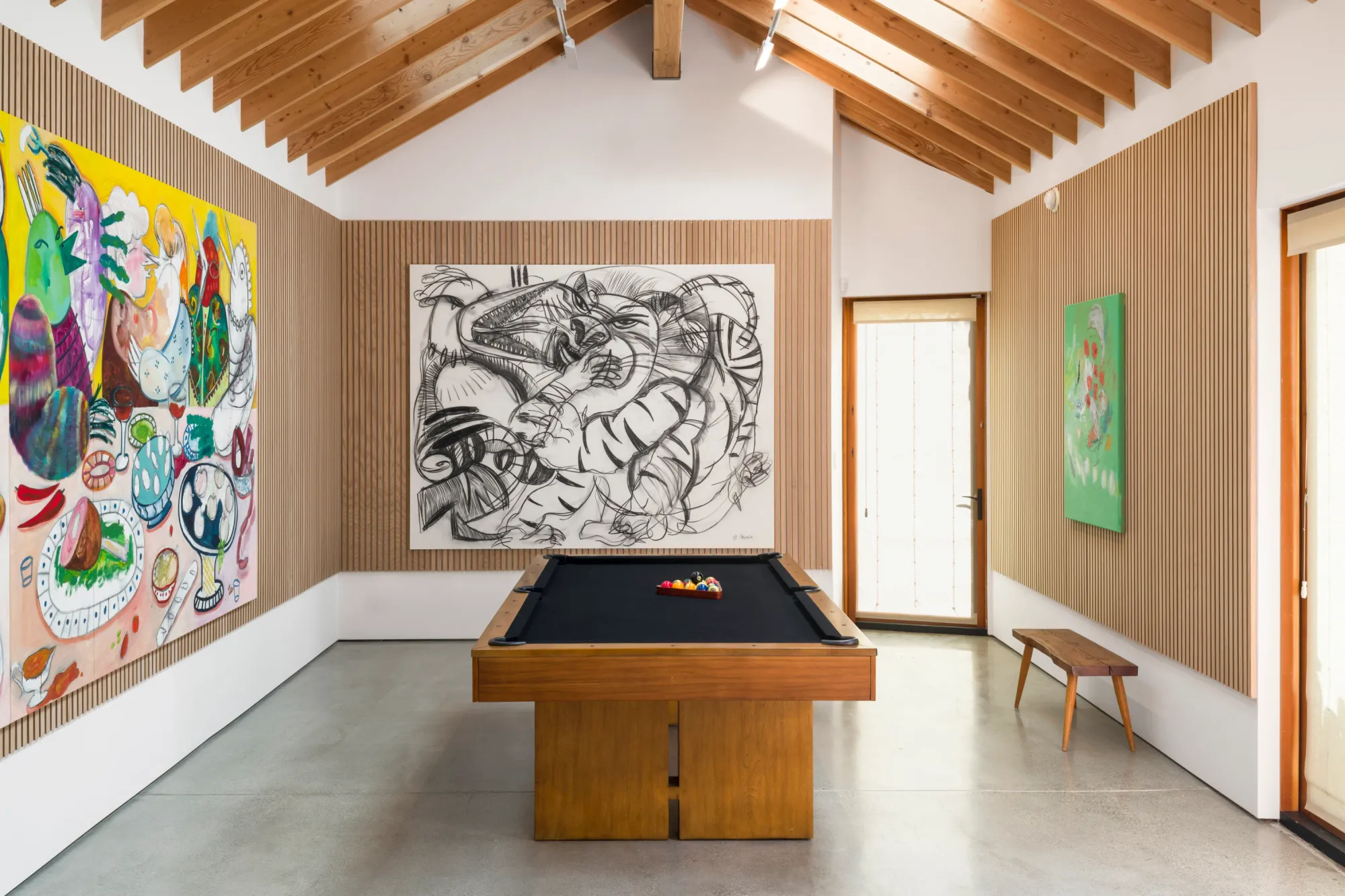 Installation view of Dinner Table at Simchowitz Hilltop, Los Angeles, with multiple paintings by Andrey Samarin and Lera Derkach displayed around a pool table.