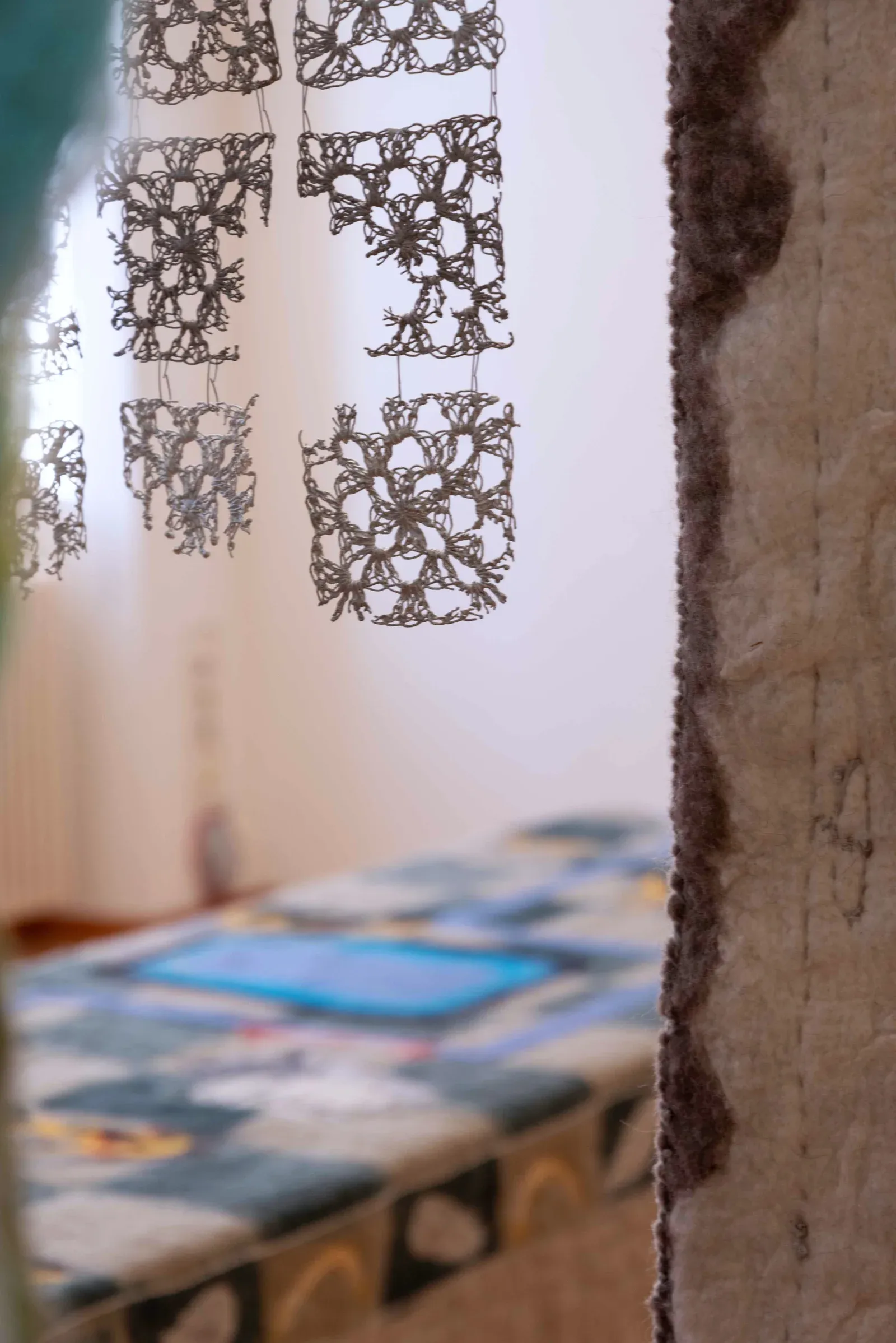 Pierre-Yves Delannoy, Pendant que les champs brûlent (2025), suspended crochet forms cast in aluminium within a textile installation, contemporary sculptural work combining textile traditions and metal casting.