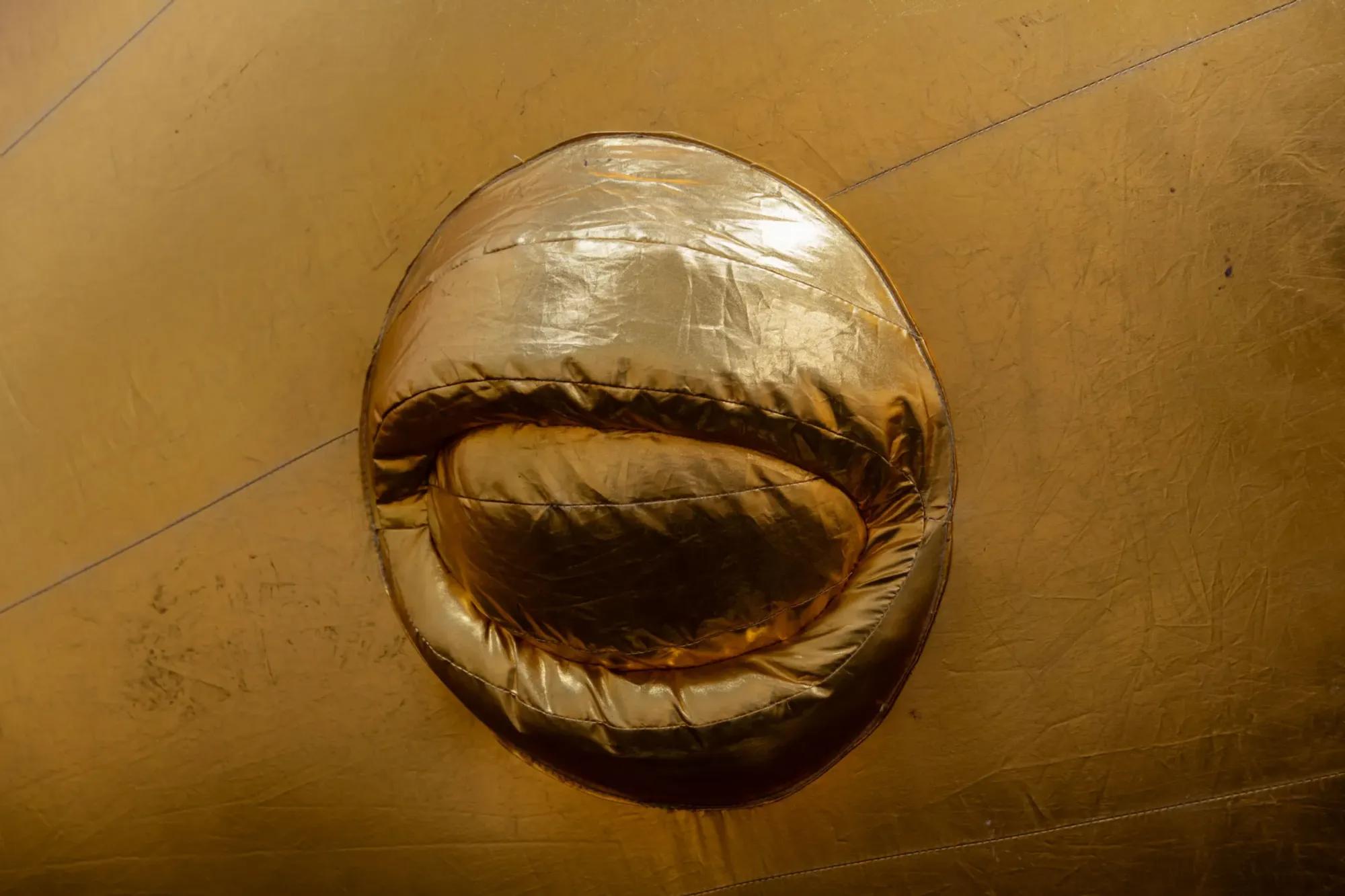 Esben Weile Kjær, Lions, exhibition detail, inflated golden sculpture surface with circular opening, St. Chads Projects London