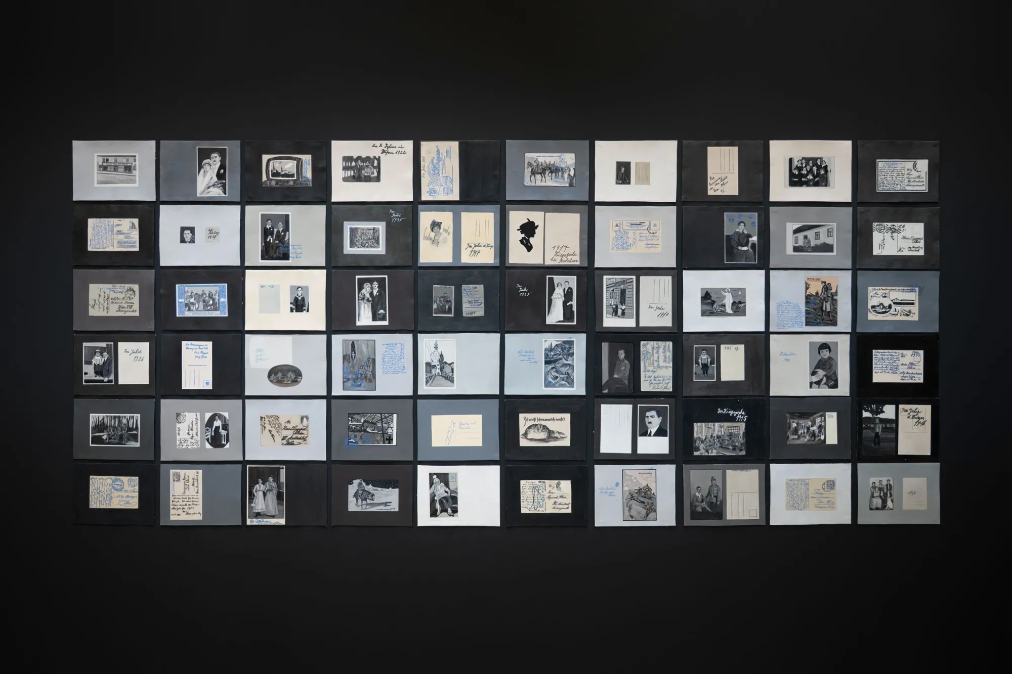 Ramesch Daha paintings from the archive grid installation postcards photographs documents black wall