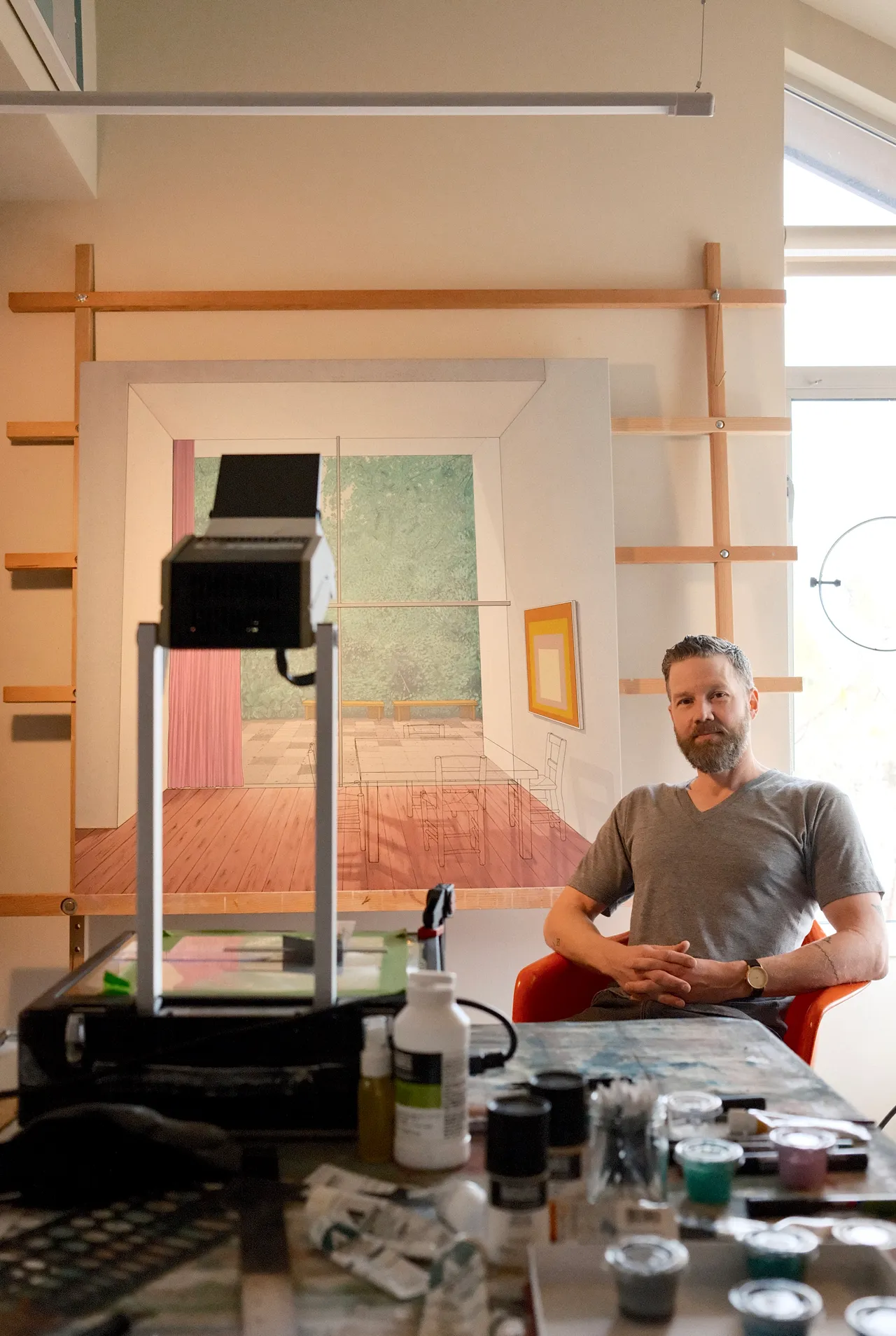 Chris Cassimatis sitting in his studio beside painting tools and a work in progress during an interview with DiFranco for Catapult Munchies Art Club.