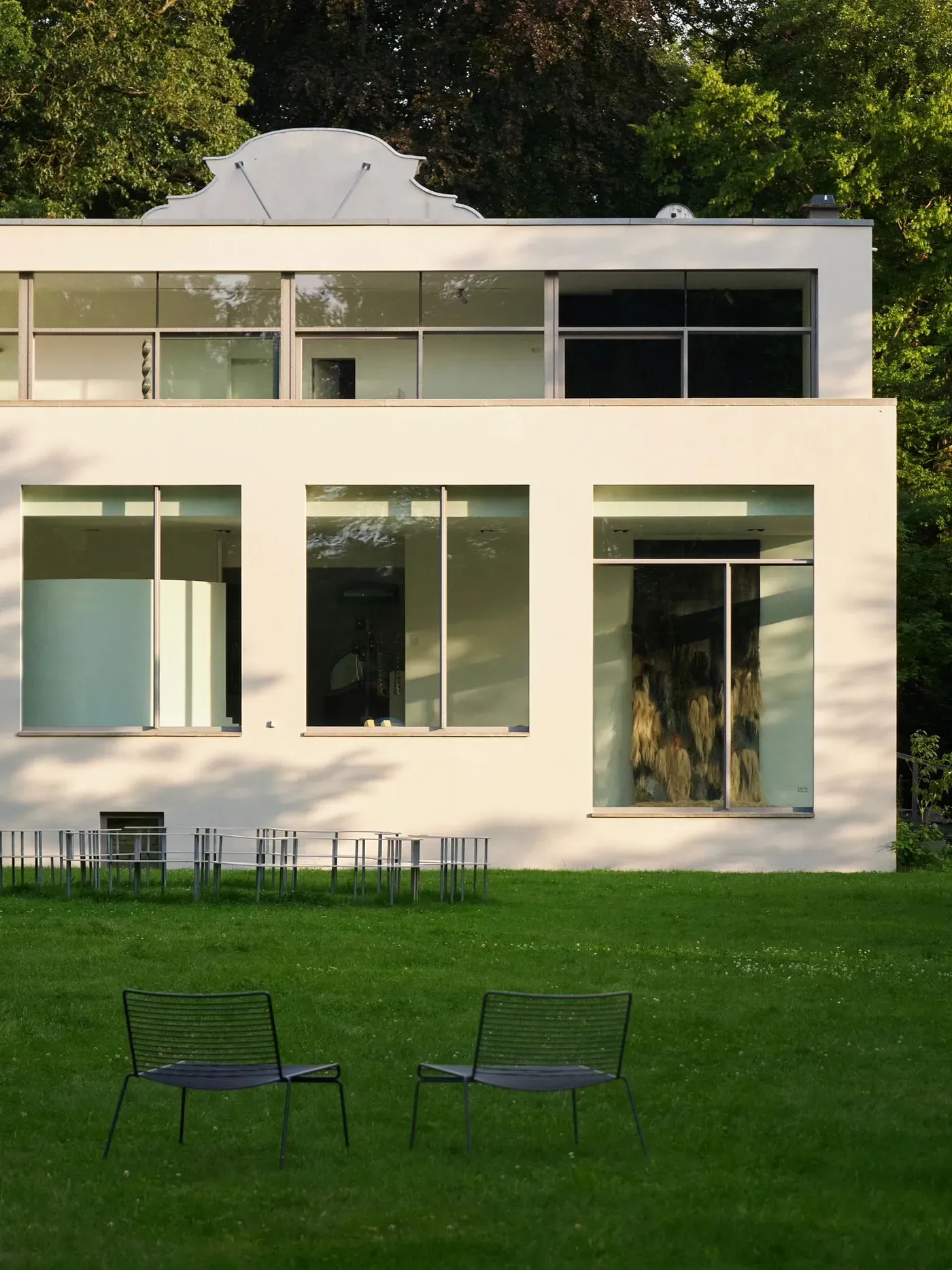 Modernist white Wehrmühle building surrounded by trees, venue of the 2025 group exhibition Some Degree of Friction.
