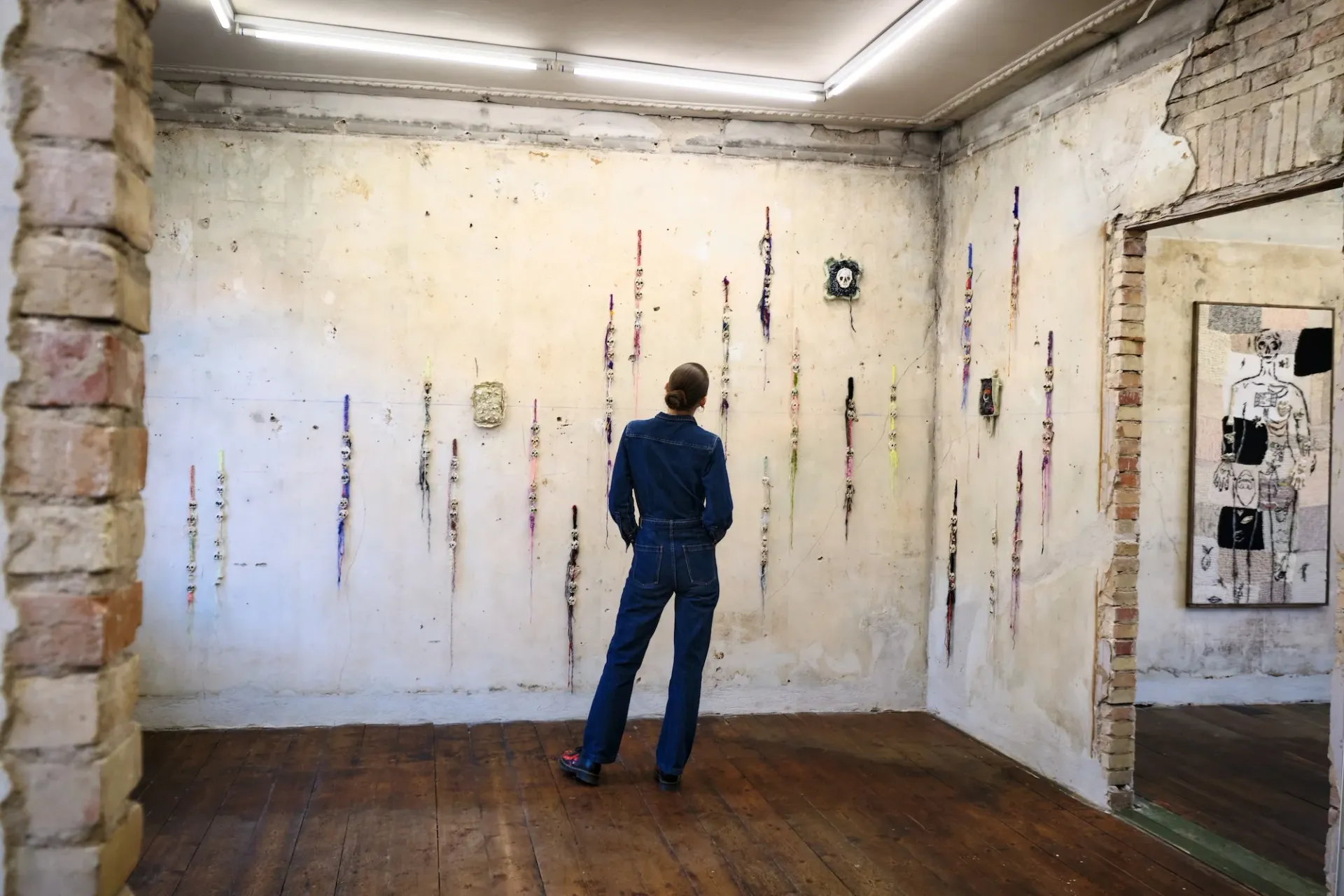 Julie Wittrup standing in front of textile wall works in her exhibition Echo at HAGD Contemporary, Aalborg