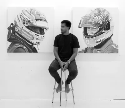 ricardo rodriguez cosme sitting in front of his formula one themed paintings figurative painting now munchies art cl